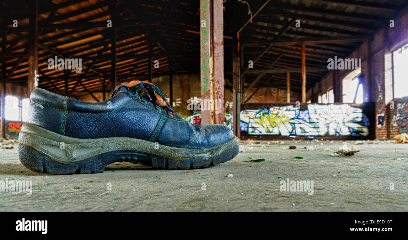 Vecchia scarpa di lavoro in una fabbrica abbandonata la costruzione di Foto Stock