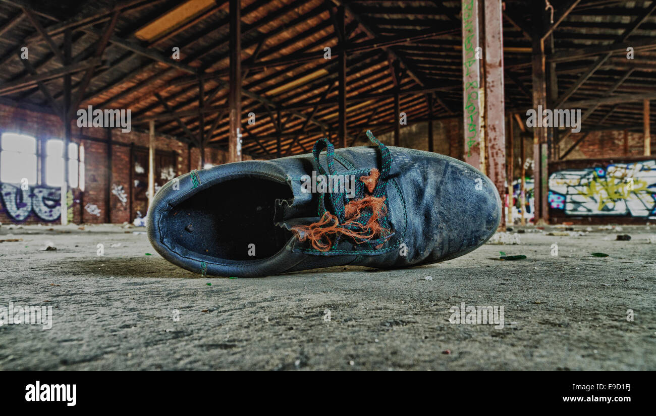 Vecchia scarpa di lavoro in una fabbrica abbandonata la costruzione di Foto Stock