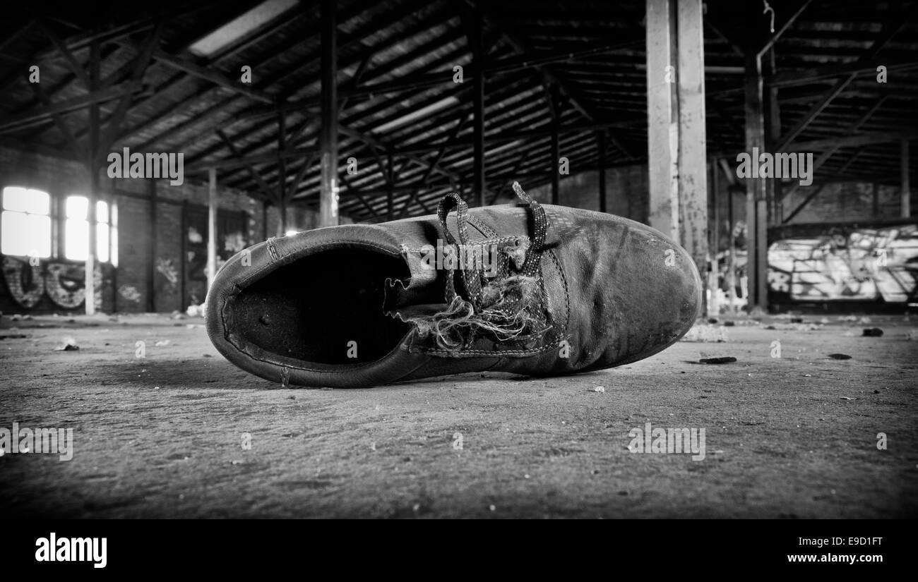 Vecchia scarpa di lavoro in una fabbrica abbandonata la costruzione di Foto Stock