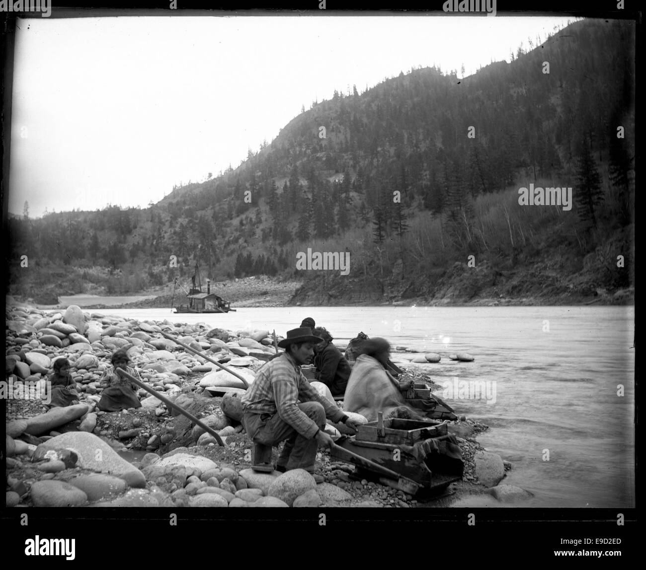 Fotografia di un gruppo di persone impegnate nel dragaggio dell'oro, che mostra le persone che partecipano a un'operazione mineraria. La fotografia cattura la natura laboriosa del dragaggio dell'oro e il suo impatto sull'ambiente. Foto Stock