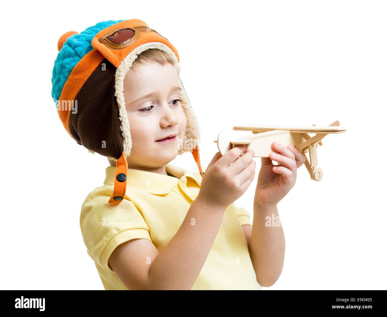 Kid boy vestito pilota guardando in legno giocattolo aereo Foto Stock