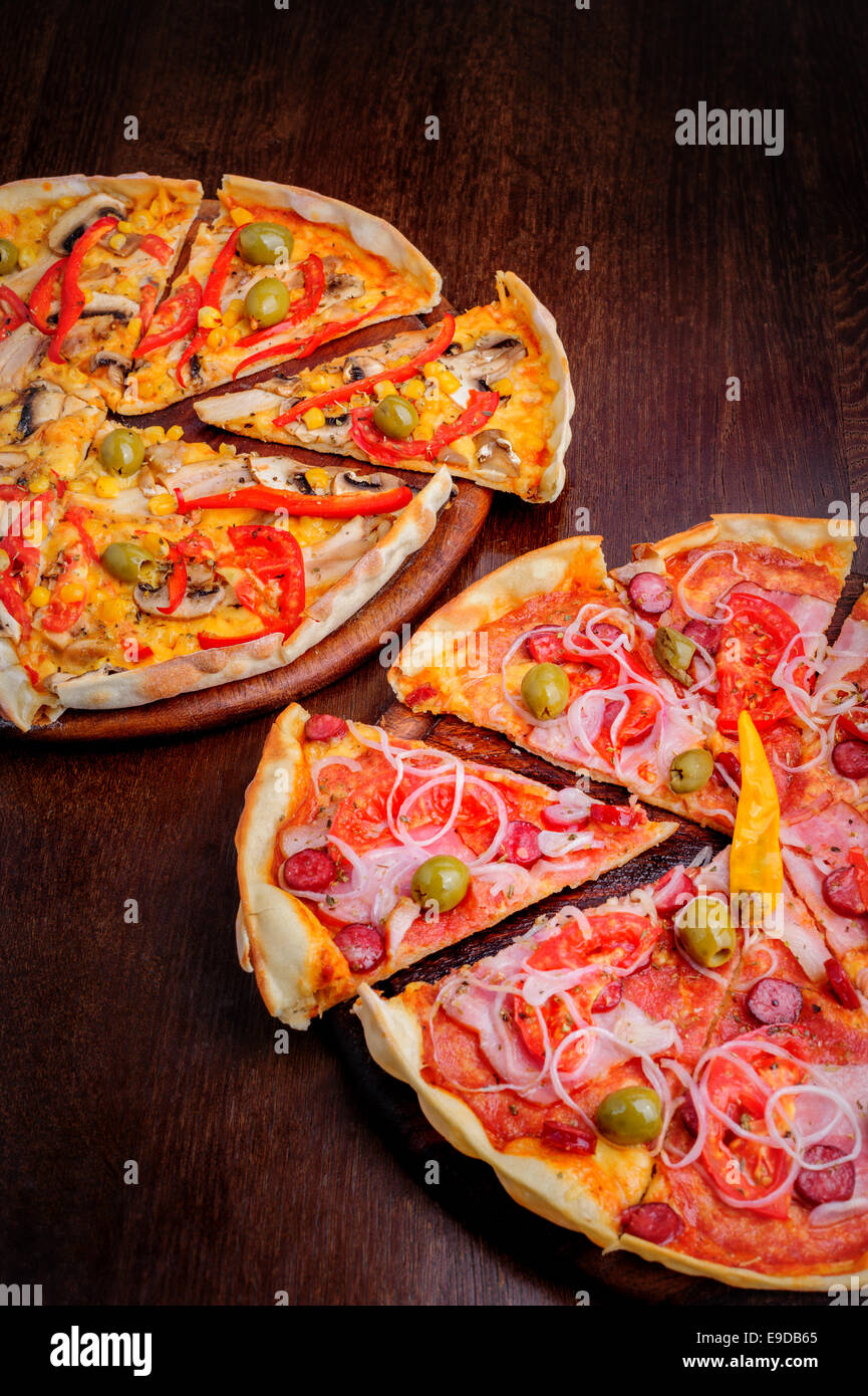 Pizza con pomodoro, salame, peppeeoni, olive e giallo pepe caldo Foto Stock
