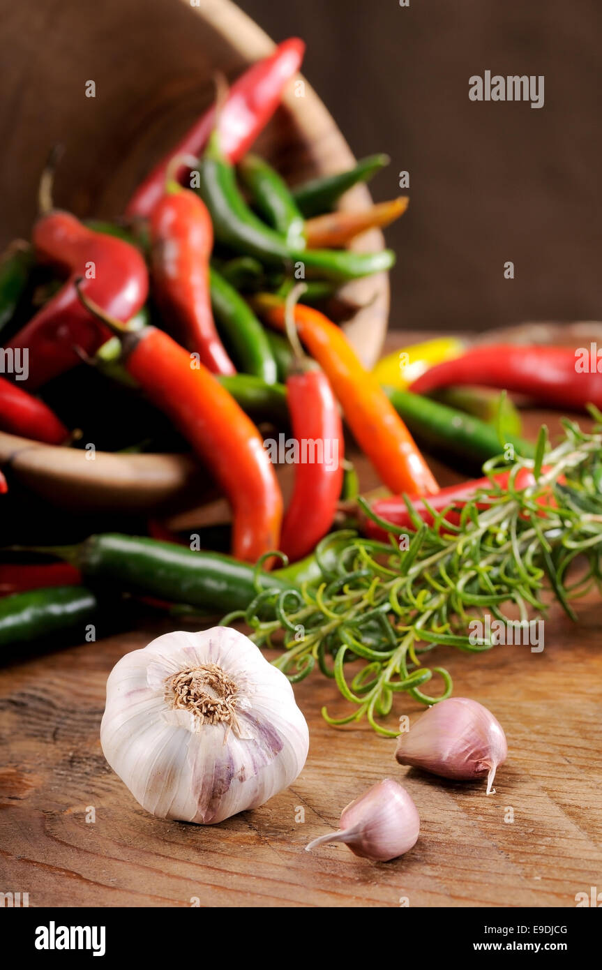 Una composizione di peperoncini rossi su una tavola di legno Foto Stock