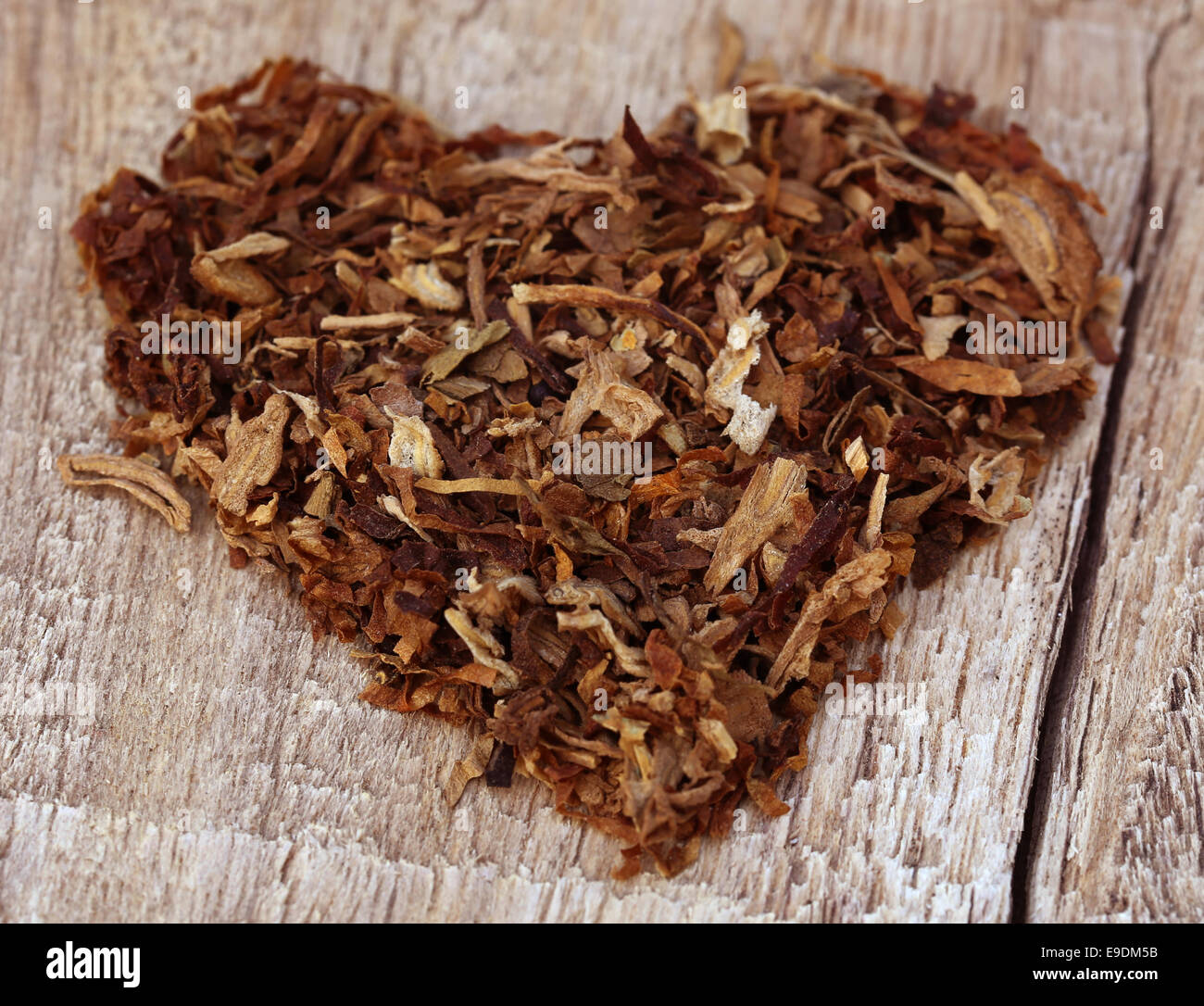Secchi di foglie di tabacco decorato a forma di cuore sulla superficie di legno Foto Stock