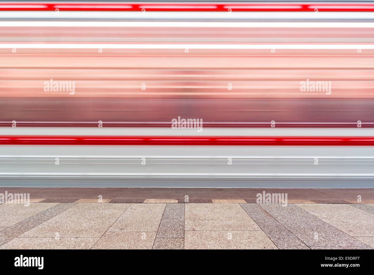 Rapido sentiero sfocata del treno in movimento del traffico in pubblico illuminato dalla stazione della metropolitana Foto Stock