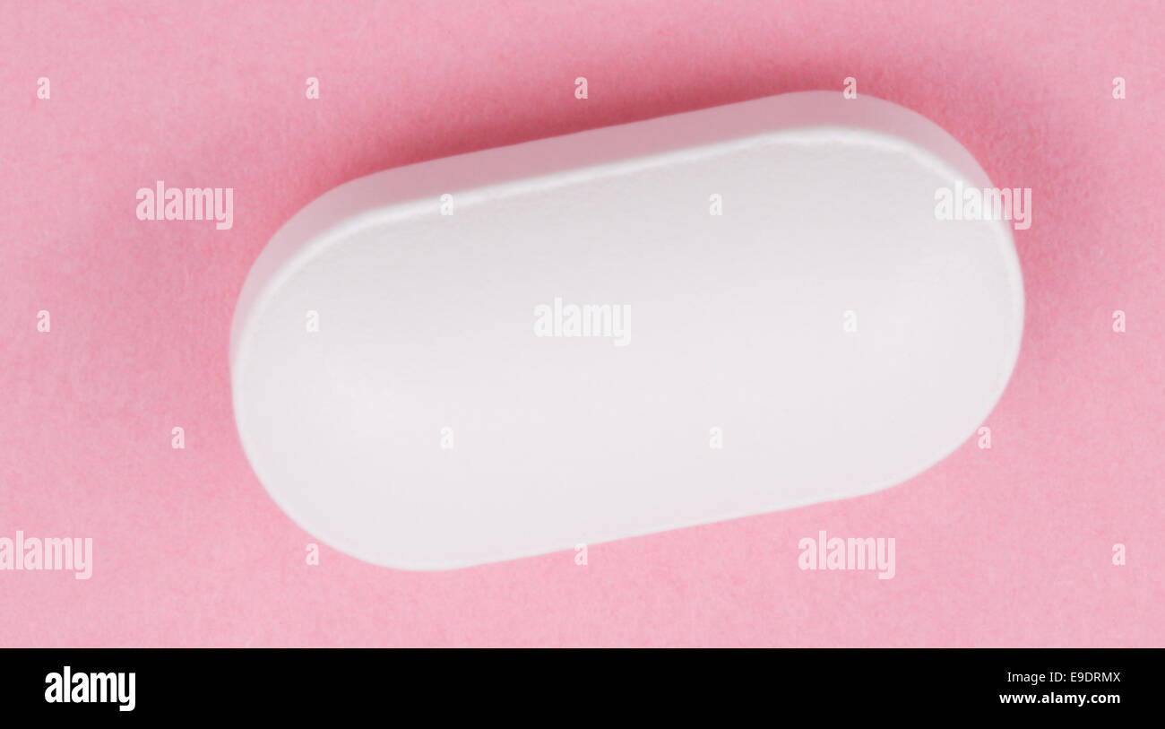 Pillola bianco su sfondo rosa Foto Stock