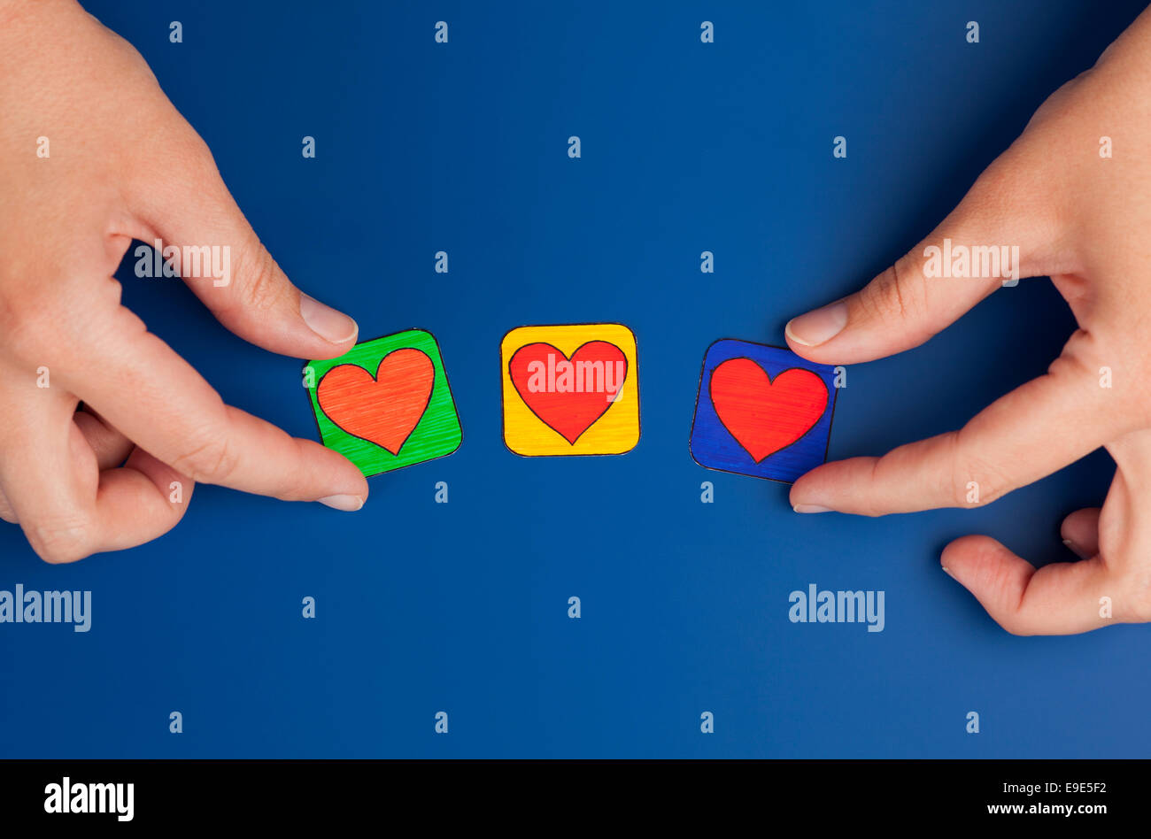 Tre cuori su sfondo blu con la donna con le mani in mano. Cuore disegnato da me. Foto Stock