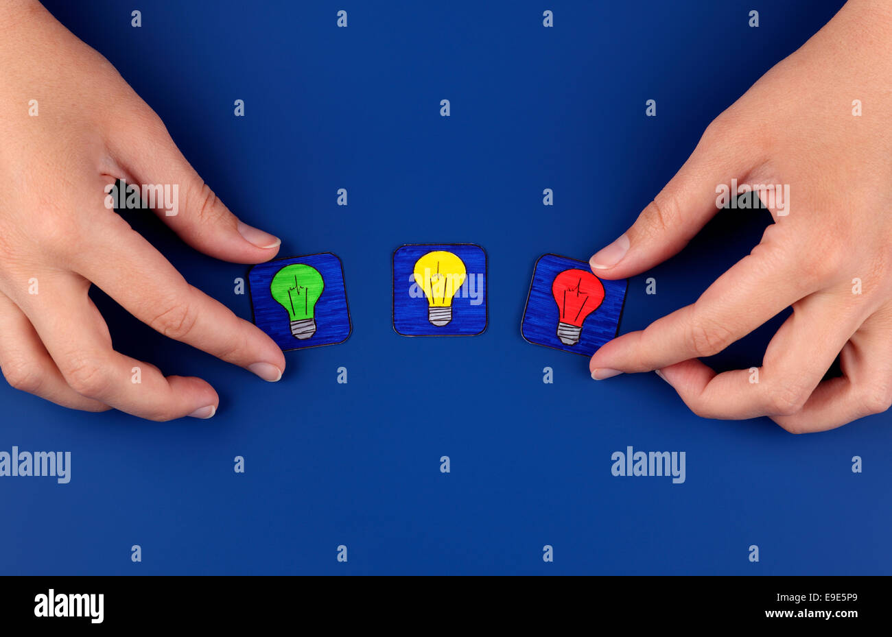 Tre lampadine su sfondo blu con la donna con le mani in mano. Immagini tratte da me. Foto Stock
