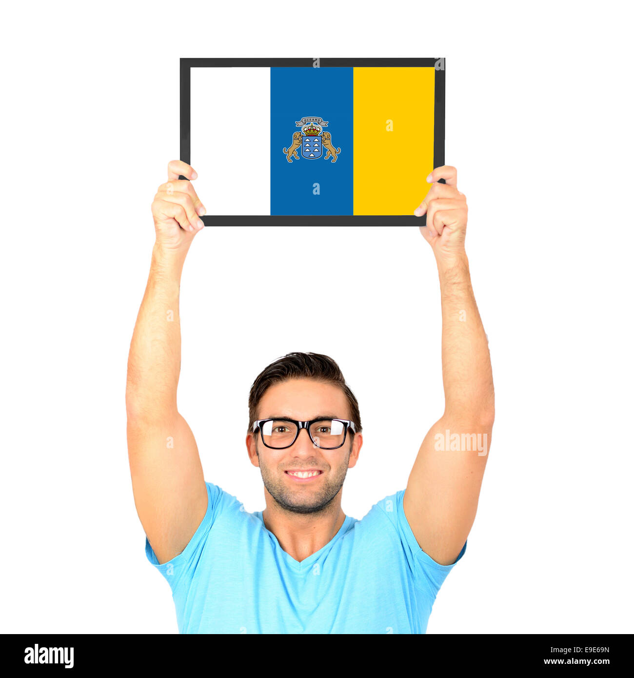 Ritratto di un giovane uomo informale tenendo su scheda con bandiera nazionale delle isole Canarie Foto Stock