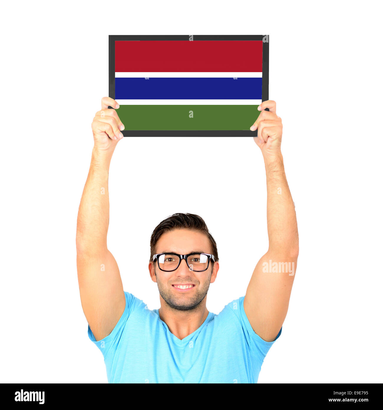 Ritratto di un giovane uomo informale tenendo su scheda con bandiera nazionale di Gambia Foto Stock