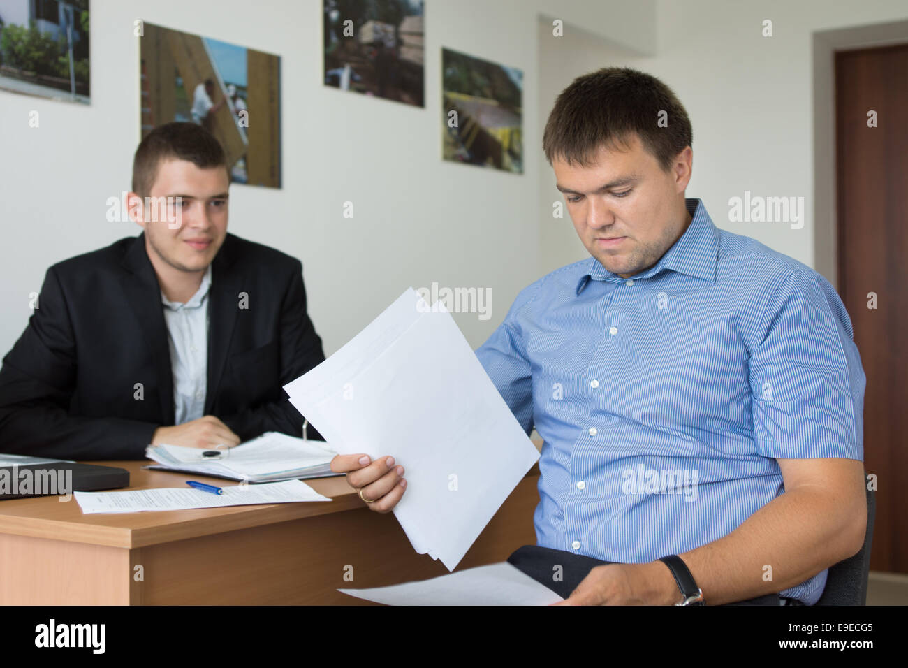 Due metà maschio età ingegneri la revisione dei documenti di progetto presso l'ufficio Foto Stock