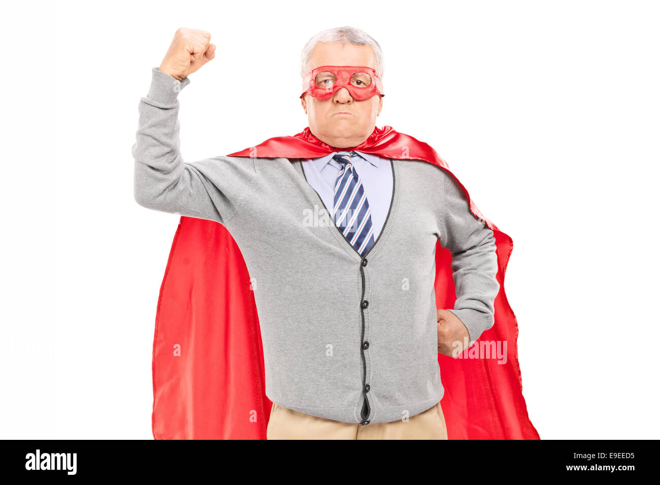 Orgoglioso uomo maturo in costume da supereroe gettando il pugno in aria isolata su sfondo bianco Foto Stock