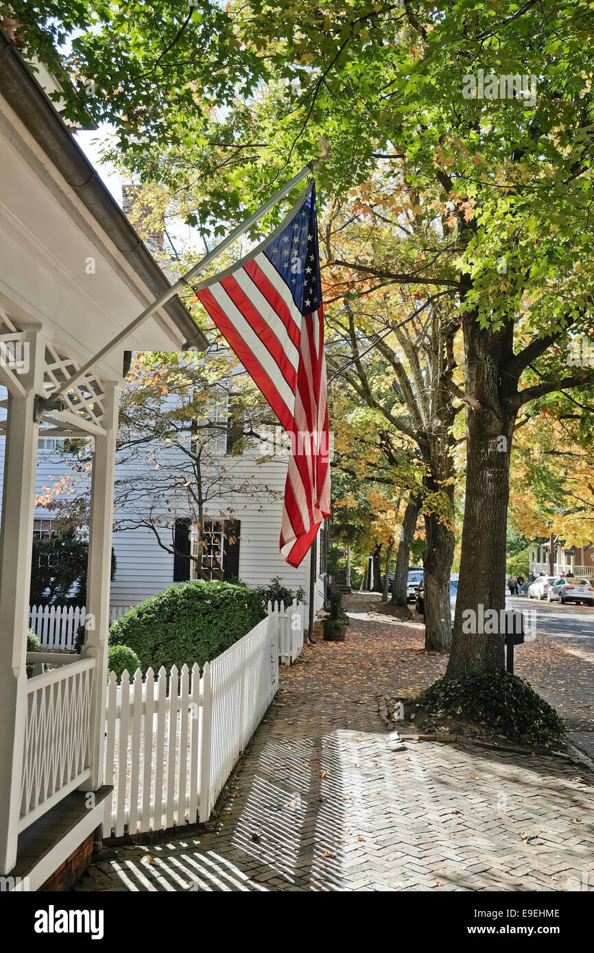 Bandiera americana off portico anteriore per l'autunno. S. lungo la strada principale di Vecchia Salem, NC Foto Stock