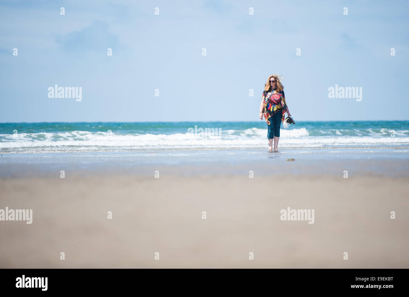 Godendo di una posizione soleggiata passeggiata sulla spiaggia Foto Stock