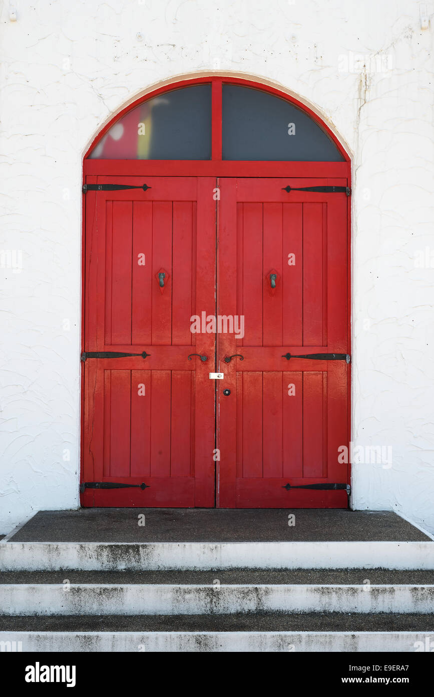 Chiuso vecchio rosso porta in legno con scale Foto Stock