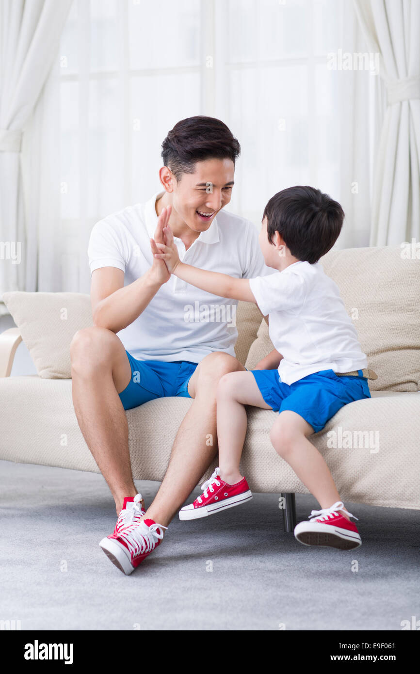 Padre e figlio giocando sul divano Foto Stock