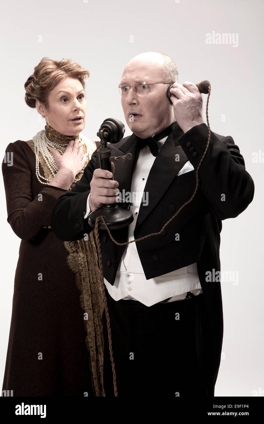 Ricerca storico Edwardian uomo donna e persone in cena giacche, costume che agiscono fuori scene in un studio bianco Foto Stock