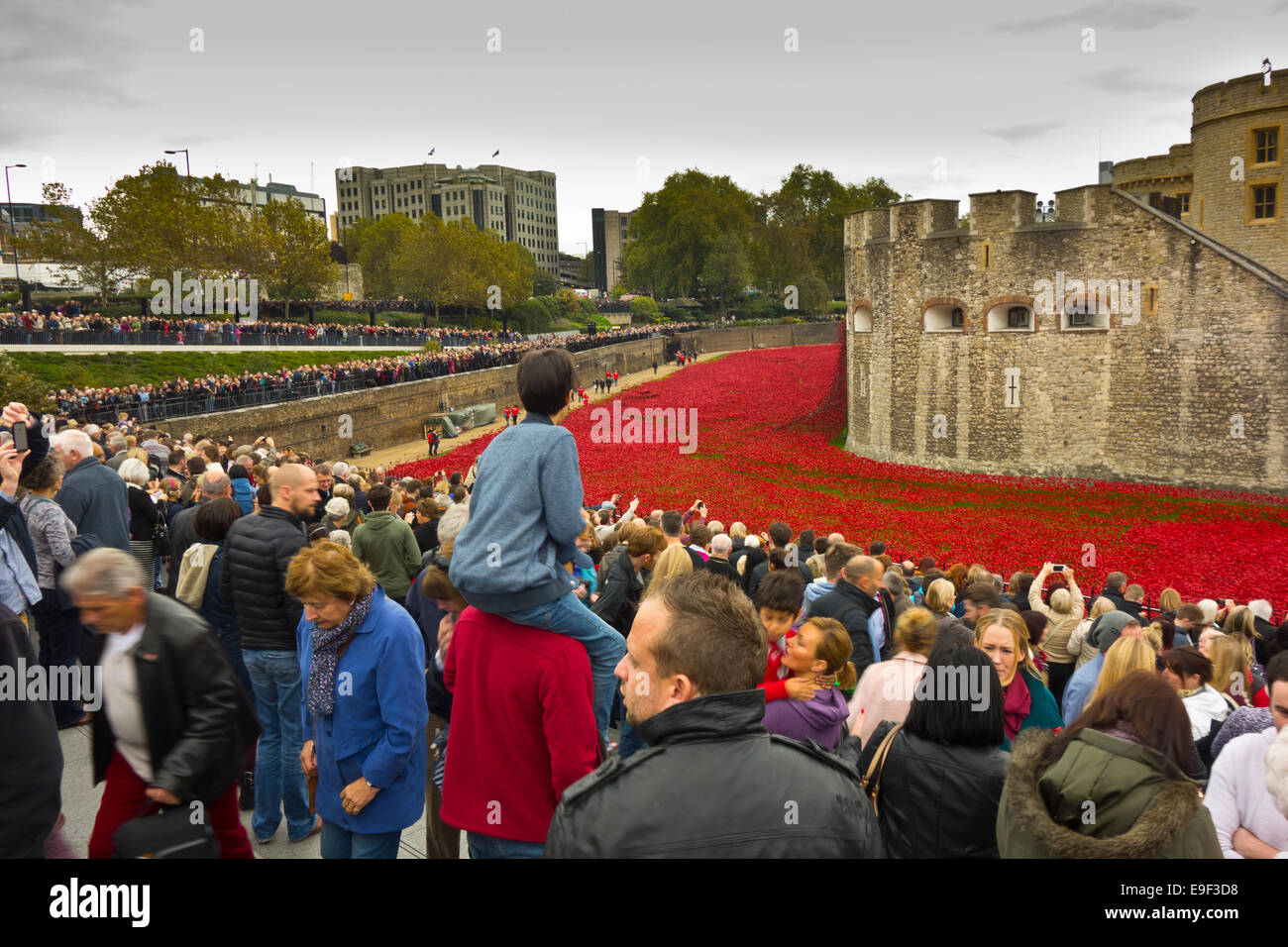 La folla di visitatori in cerca presso la Torre di Londra papaveri ricordo display Foto Stock