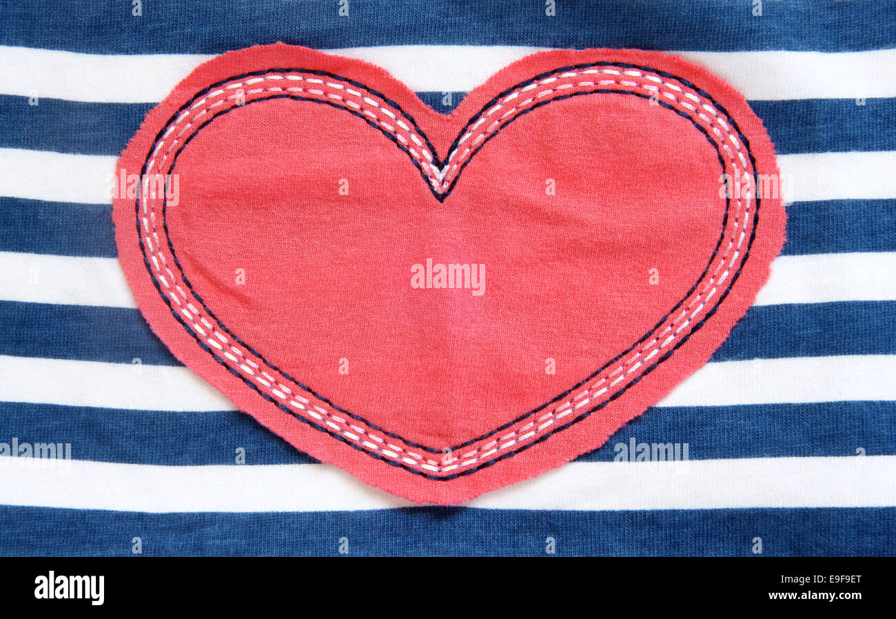Cuore rosso sul tessile un sfondo a strisce Foto Stock