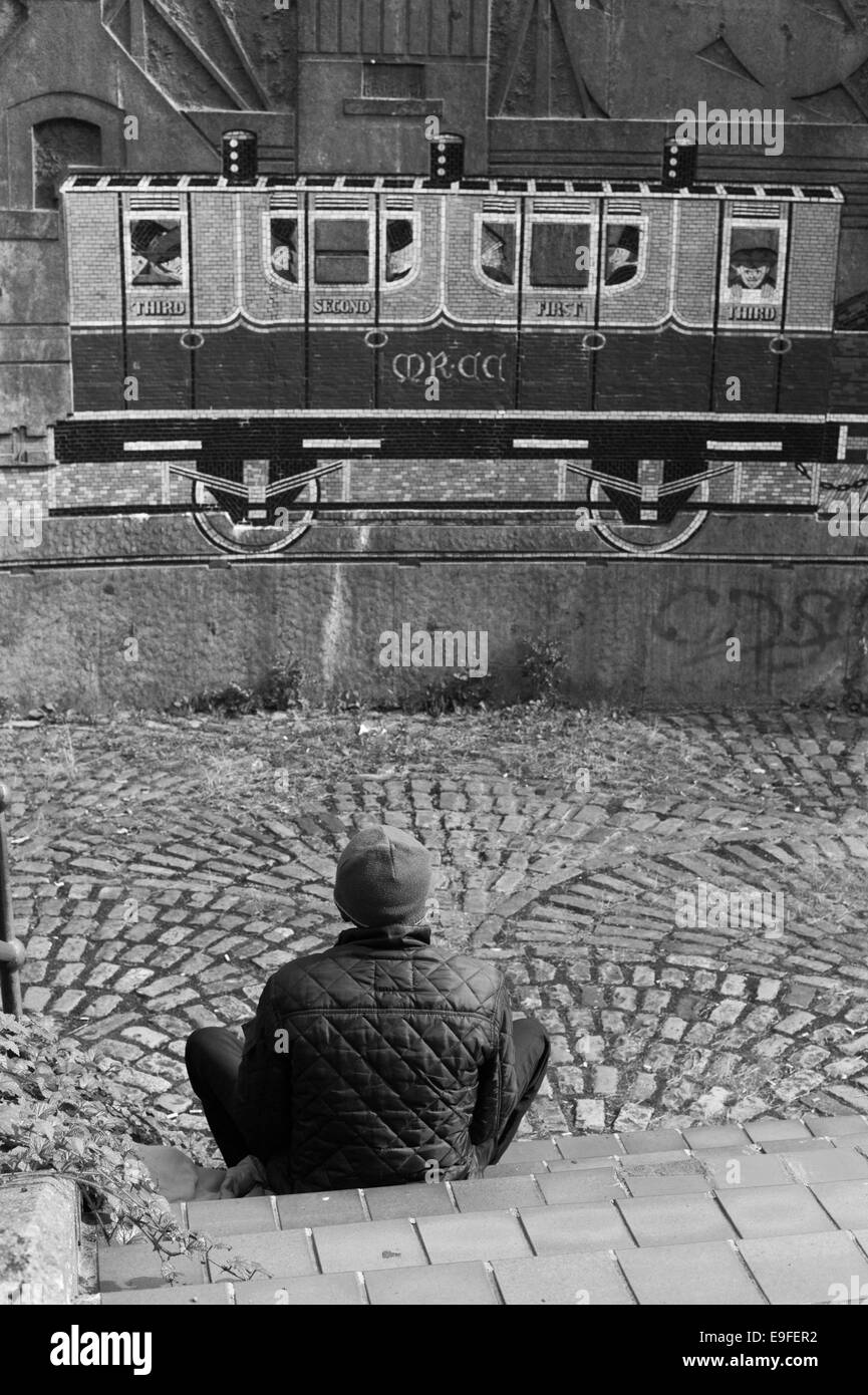 Uomo che guarda un mosaico murale. Foto Stock