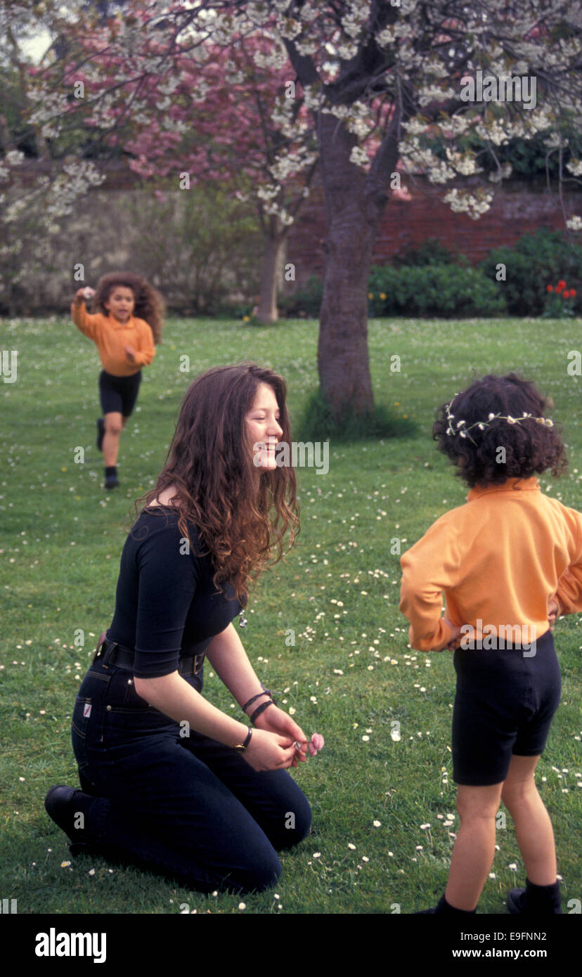 Childminder giocando con due ragazze in giardino Foto Stock