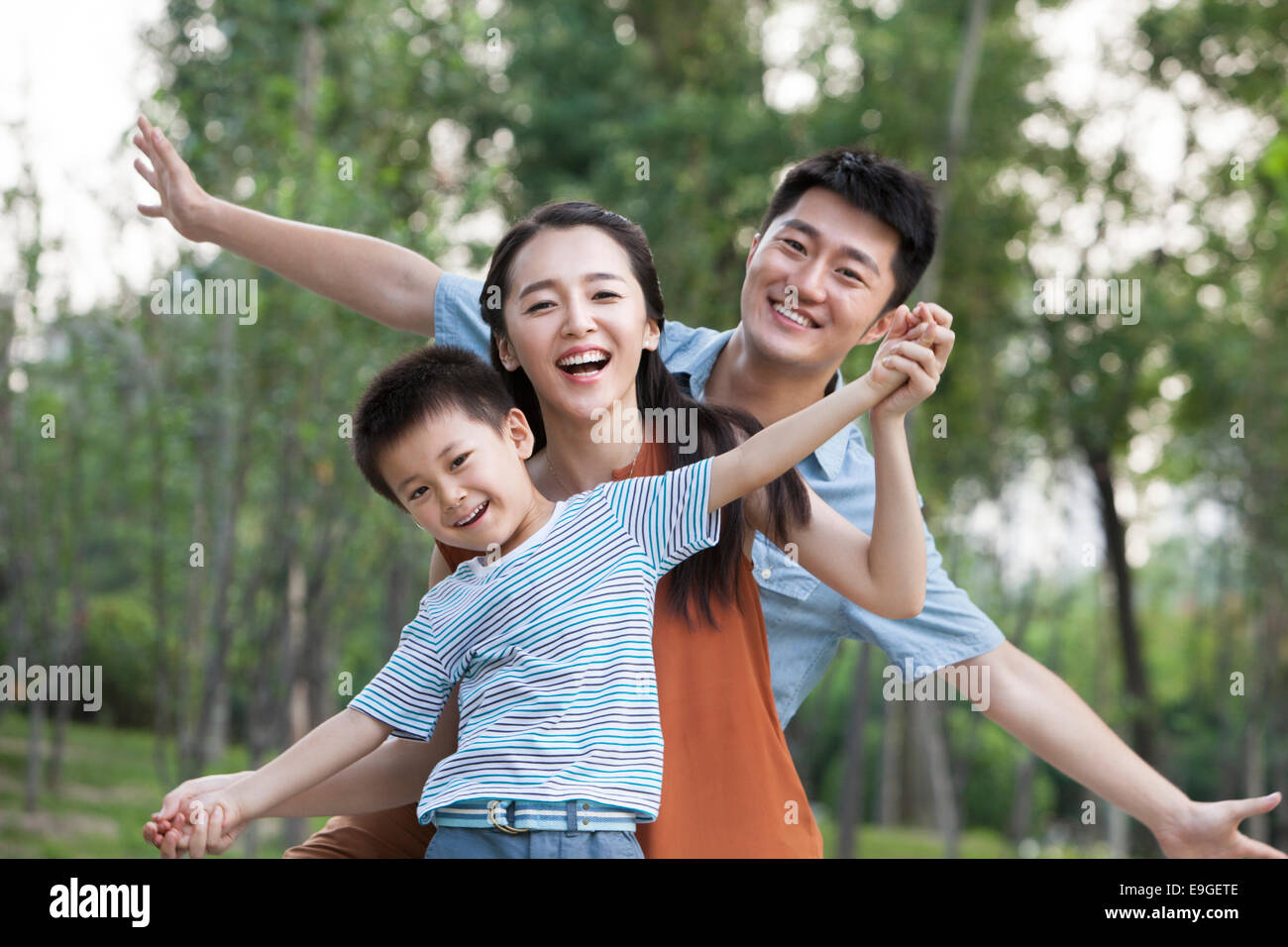 Ritratto di felice famiglia giovane con le braccia aperte Foto Stock