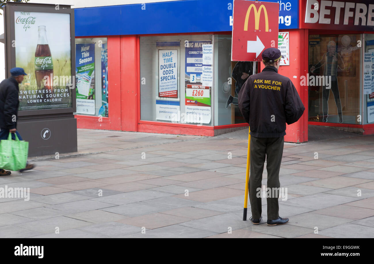McDonald's dipendente con street banner pubblicitario, Coventry, England, Regno Unito Foto Stock