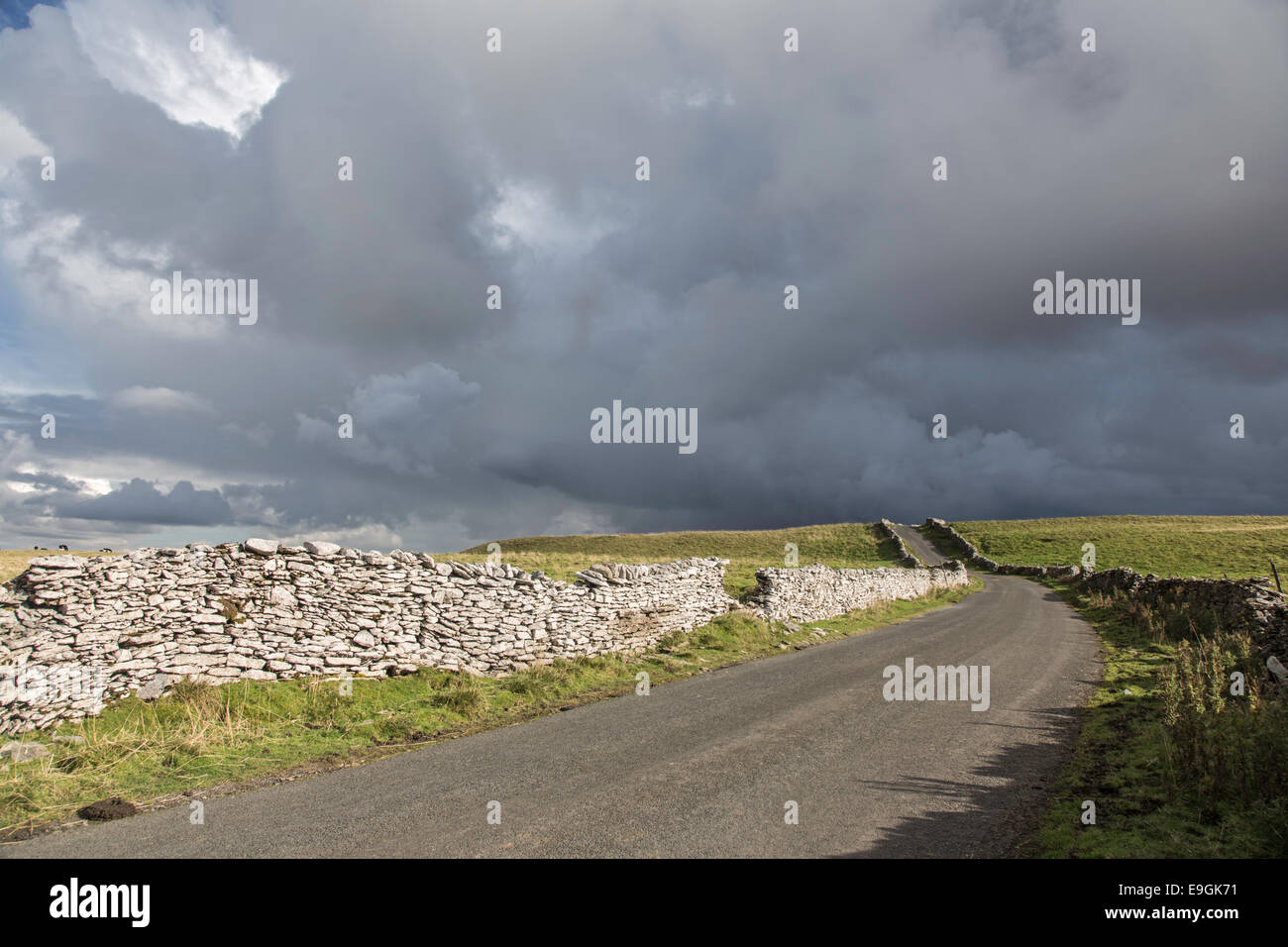 Nuvole temporalesche su un dales country lane, Yorkshire Dales National Park, North Yorkshire, Inghilterra, Regno Unito Foto Stock