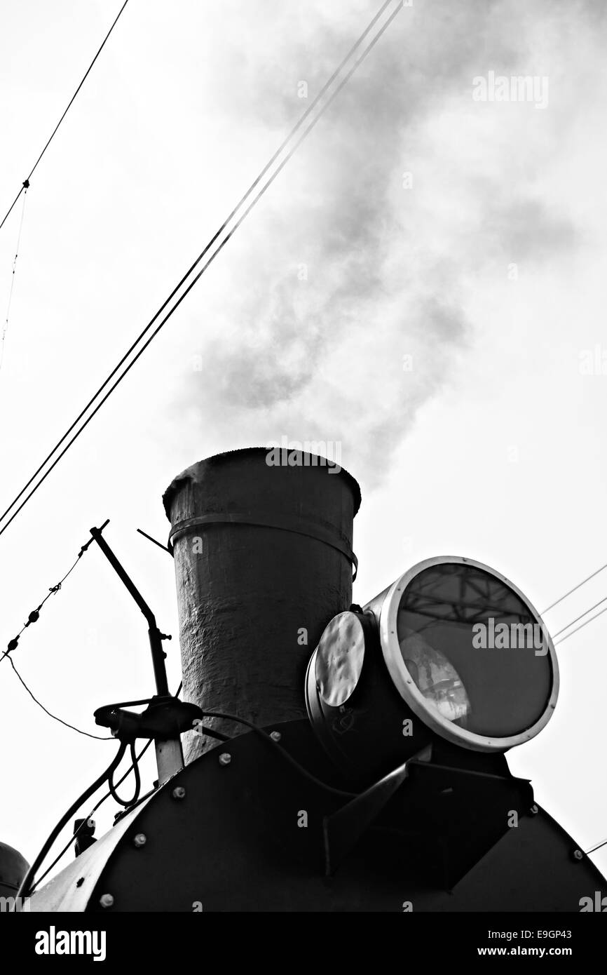 Locomotiva a vapore in vapore e pronto alla partenza. Vista parziale di nero caldaia e camino. Esce del fumo di un camino Foto Stock