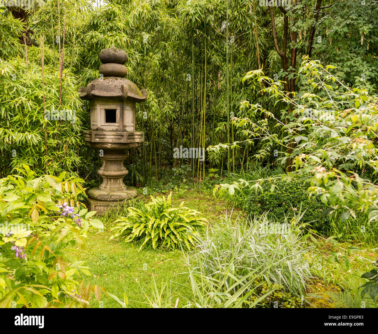 Una scultura si siede tra le piante verdi. Foto Stock