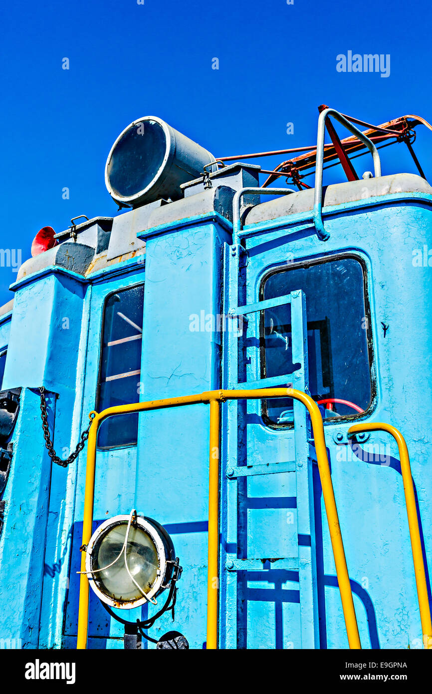 Vista ingrandita di un servizio ferroviario elettrico motore di colore blu contro lo sfondo del cielo blu chiaro Foto Stock