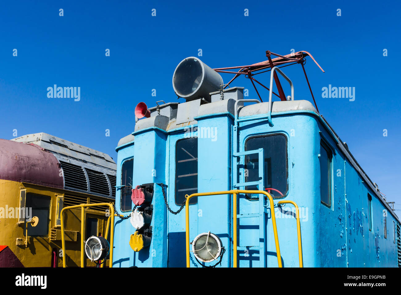 Vista ingrandita di un servizio ferroviario elettrico motore di colore blu contro lo sfondo del cielo blu chiaro Foto Stock