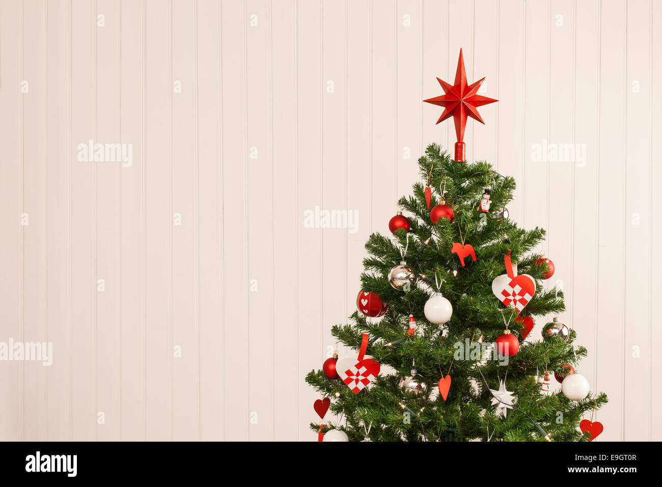 Dettaglio di un bellissimo albero di Natale insieme contro una parete in legno per lo spazio di copia Foto Stock