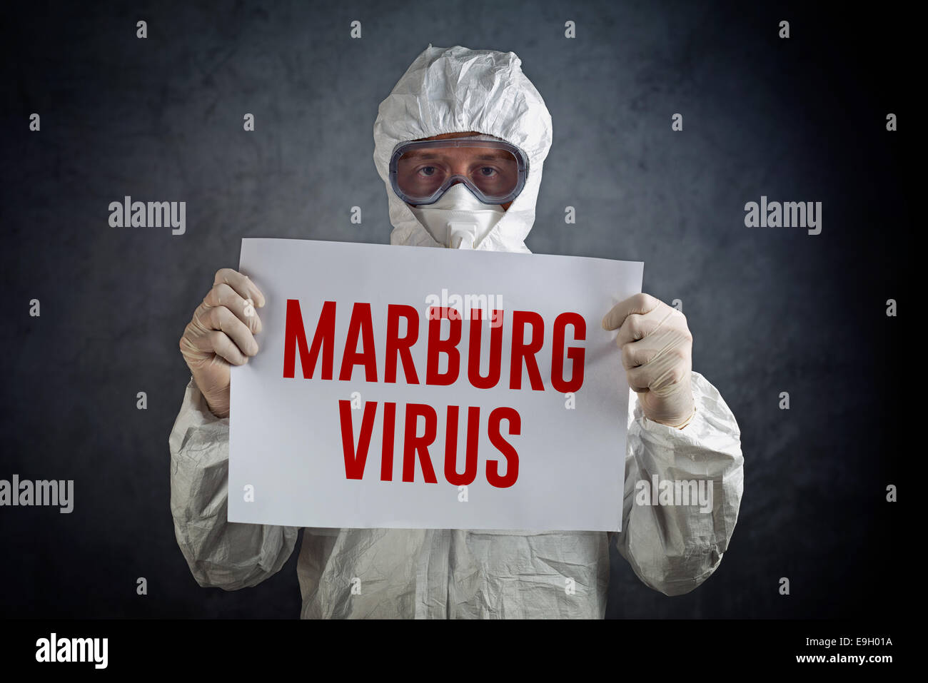 Medical healh care Lavoratore che indossa mantellina protettiva, guanti, maschere e occhiali di sicurezza e tenendo la carta con titolo virus di Marburg. Foto Stock
