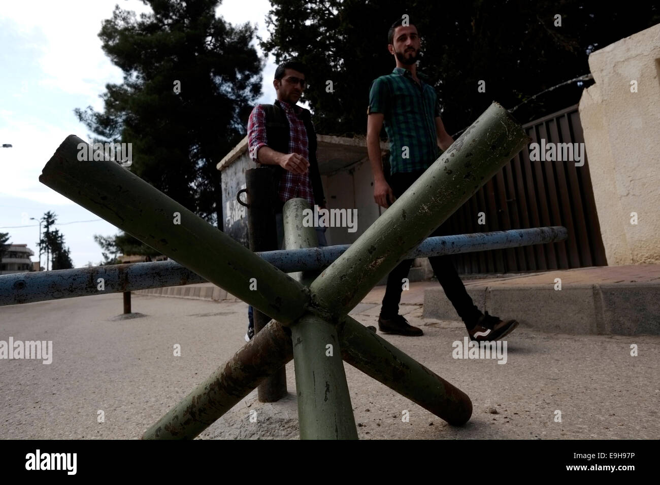 Pedoni che attraversano una barricata in strada nella città di Al-Malikiyah anche chiamato Derek ( ) curda in Al Hasakah o distretto Hassakeh nella Siria settentrionale Foto Stock