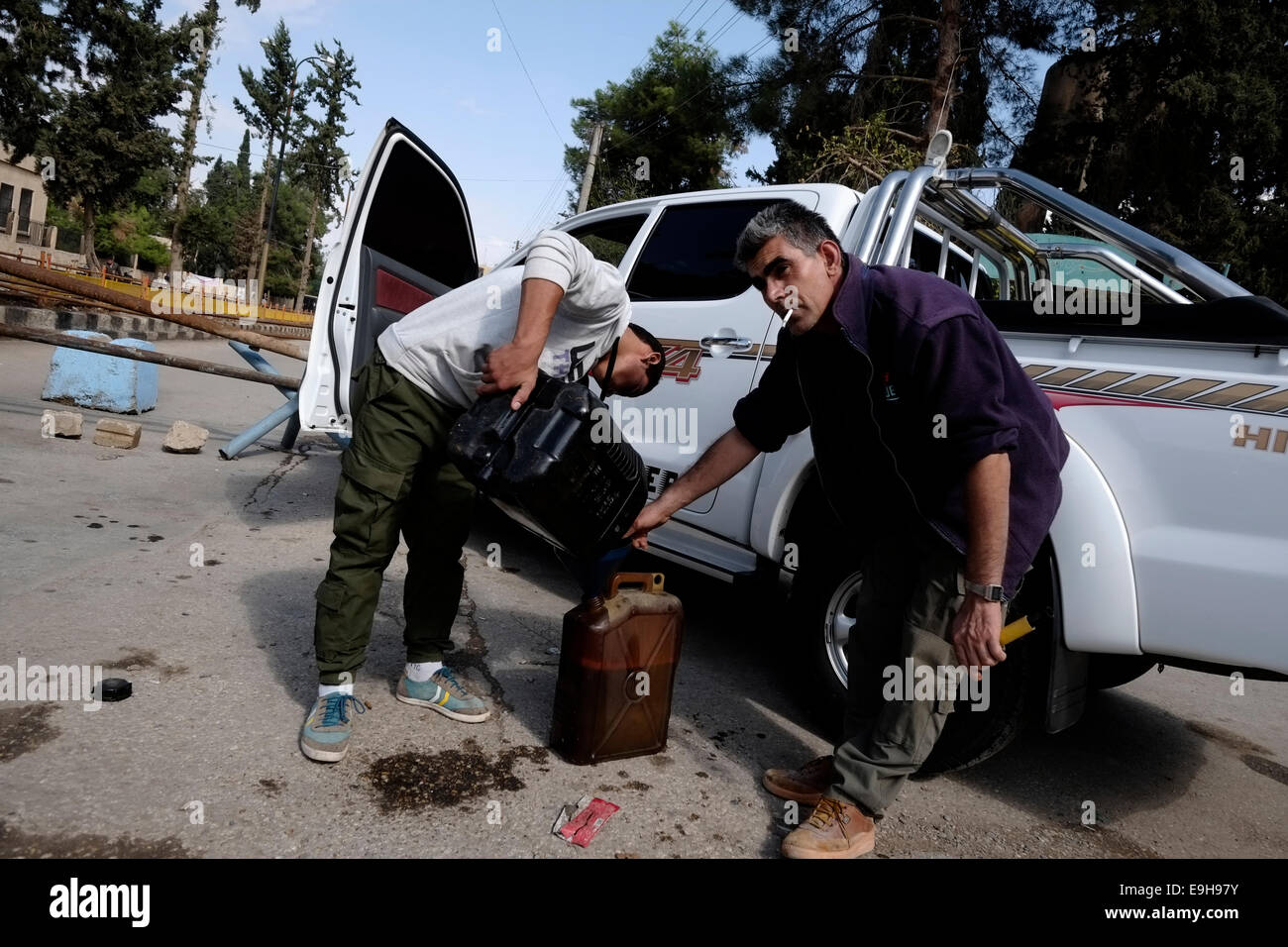 Uomini curda il deposito di benzina in bidoni nella città di Al-Malikiyah anche chiamato Derek ( ) curda in Al Hasakah o distretto Hassakeh nella Siria settentrionale Foto Stock