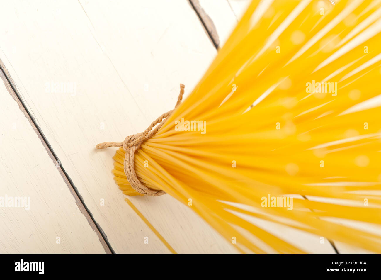 La pasta italiana spaghetti legato con una corda su un tavolo rustico Foto Stock