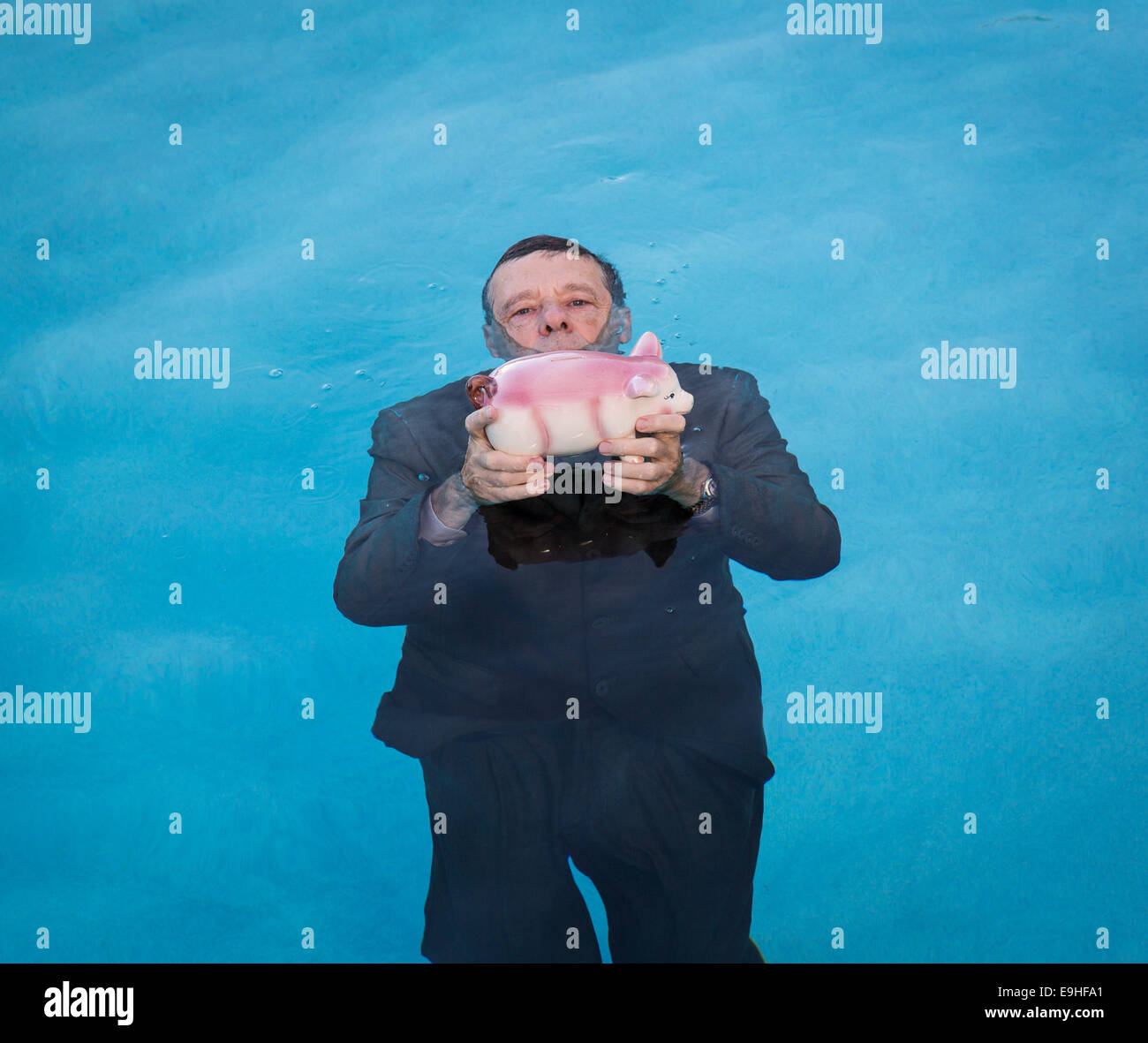 Senior man holding salvadanaio sopra l'acqua Foto Stock