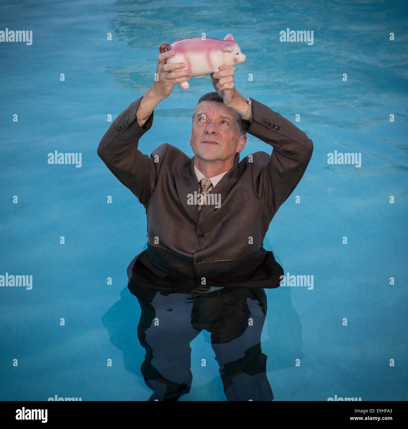 Senior man holding salvadanaio sopra l'acqua Foto Stock