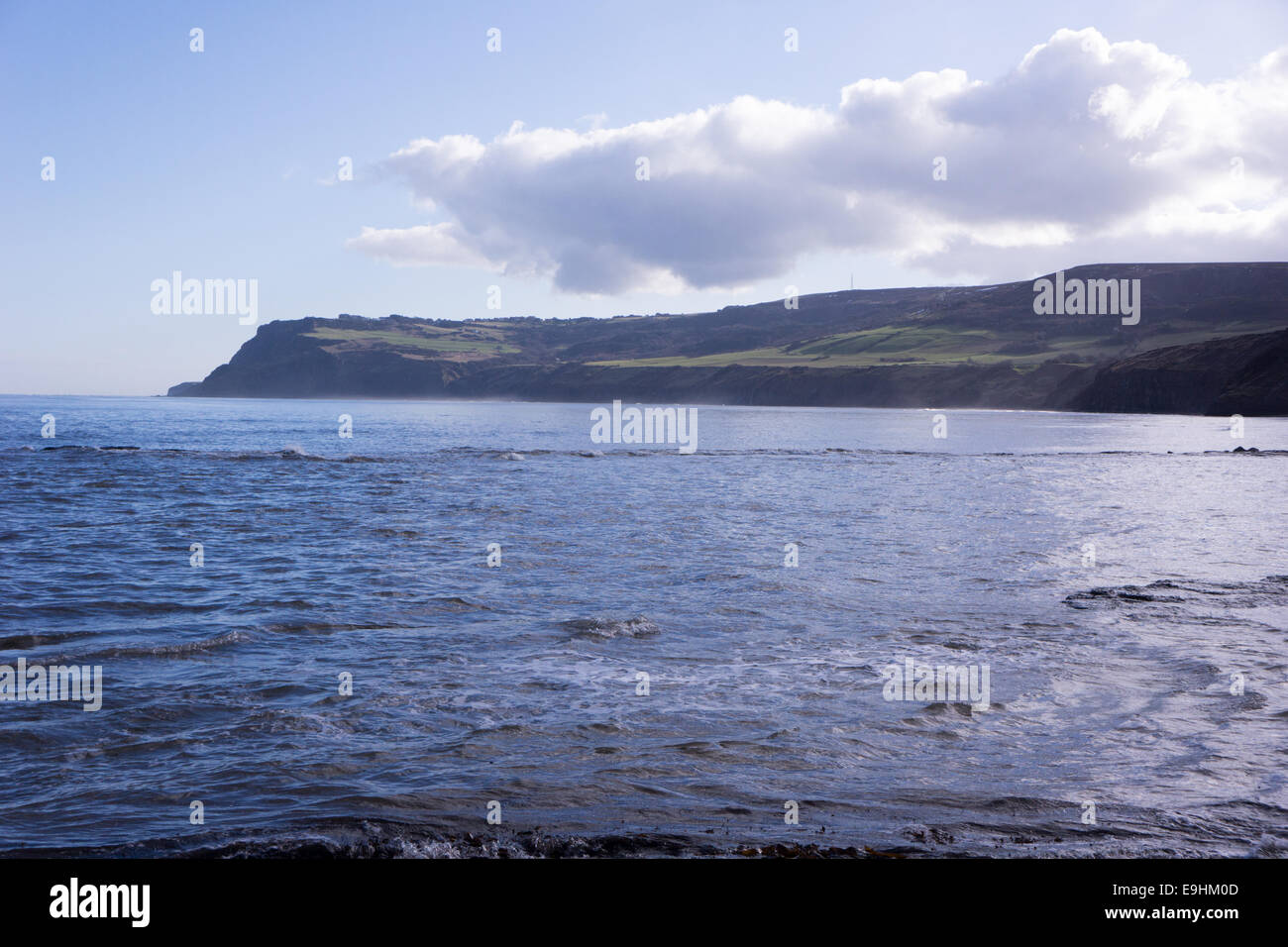 Dinosaur Coast, North Yorkshire. Vista dalla luce del sole sulla costa del North Yorkshire con promontori ondulati, mare calmo e nuvole luminose che attraversano il cielo. Foto Stock
