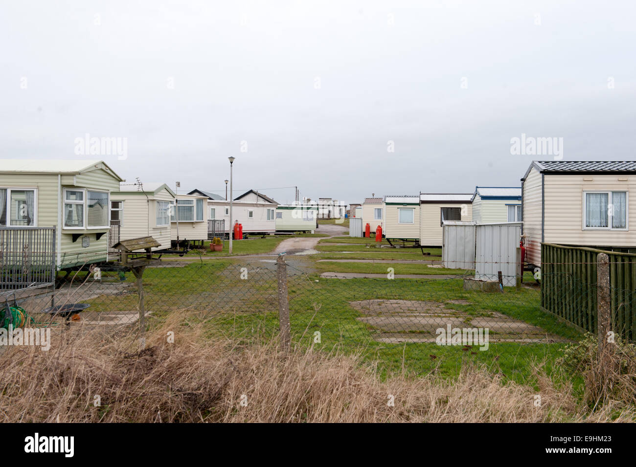 Carovane statiche in una giornata tranquilla e ricoperta a Kilnsea, mostrando un parco vacanze costiero sparso con servizi semplici. Foto Stock