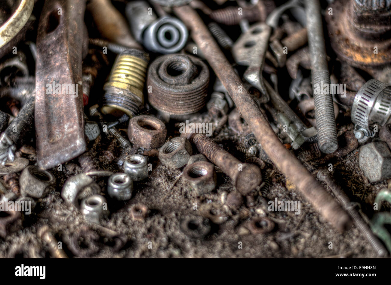 Varie vecchie e arrugginite i dadi, i bulloni e gli strumenti su un banco di lavoro. Foto Stock