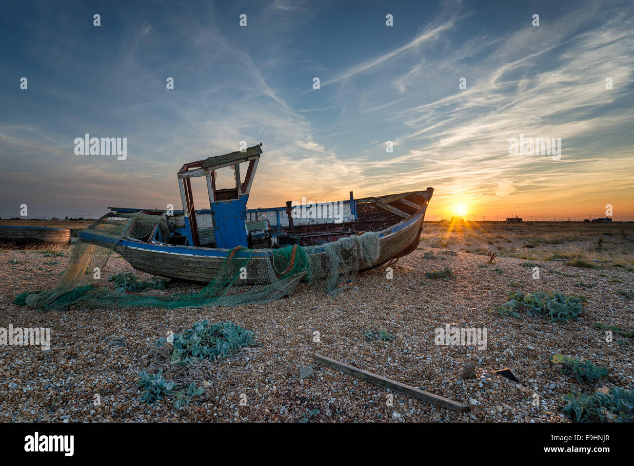 La pesca in barca sulla spiaggia al tramonto Foto Stock