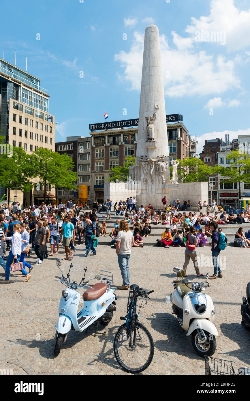 La gente seduta sui gradini del monumento nazionale in piazza Dam, Amsterdam, Paesi Bassi Foto Stock
