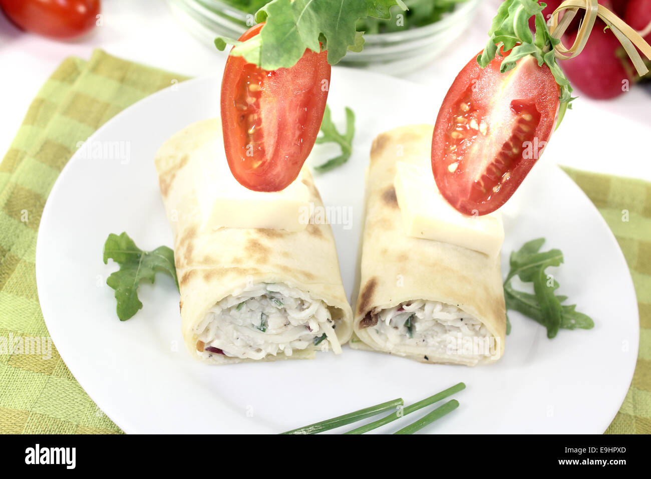 Ripiene di formaggio rotoli crêpe con pomodori su uno sfondo luminoso Foto Stock