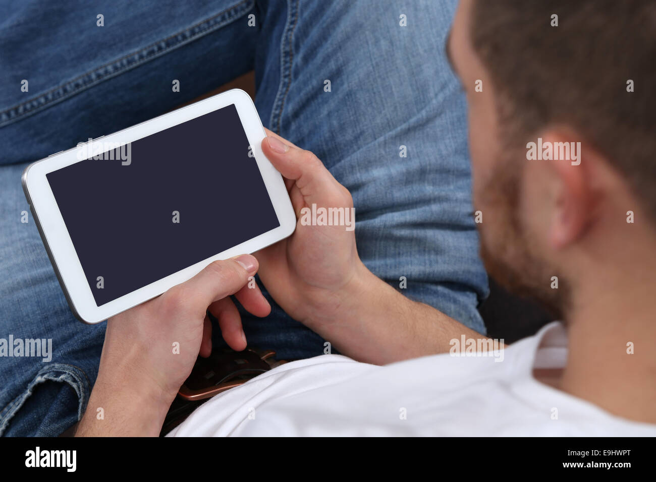 Giovane uomo utilizzando internet e guardando il proprio computer tablet Foto Stock