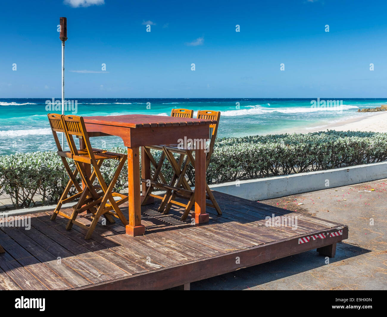 Ristorante sedie e tavolo in corrispondenza di una posizione sul fronte spiaggia in Barbados. Foto Stock