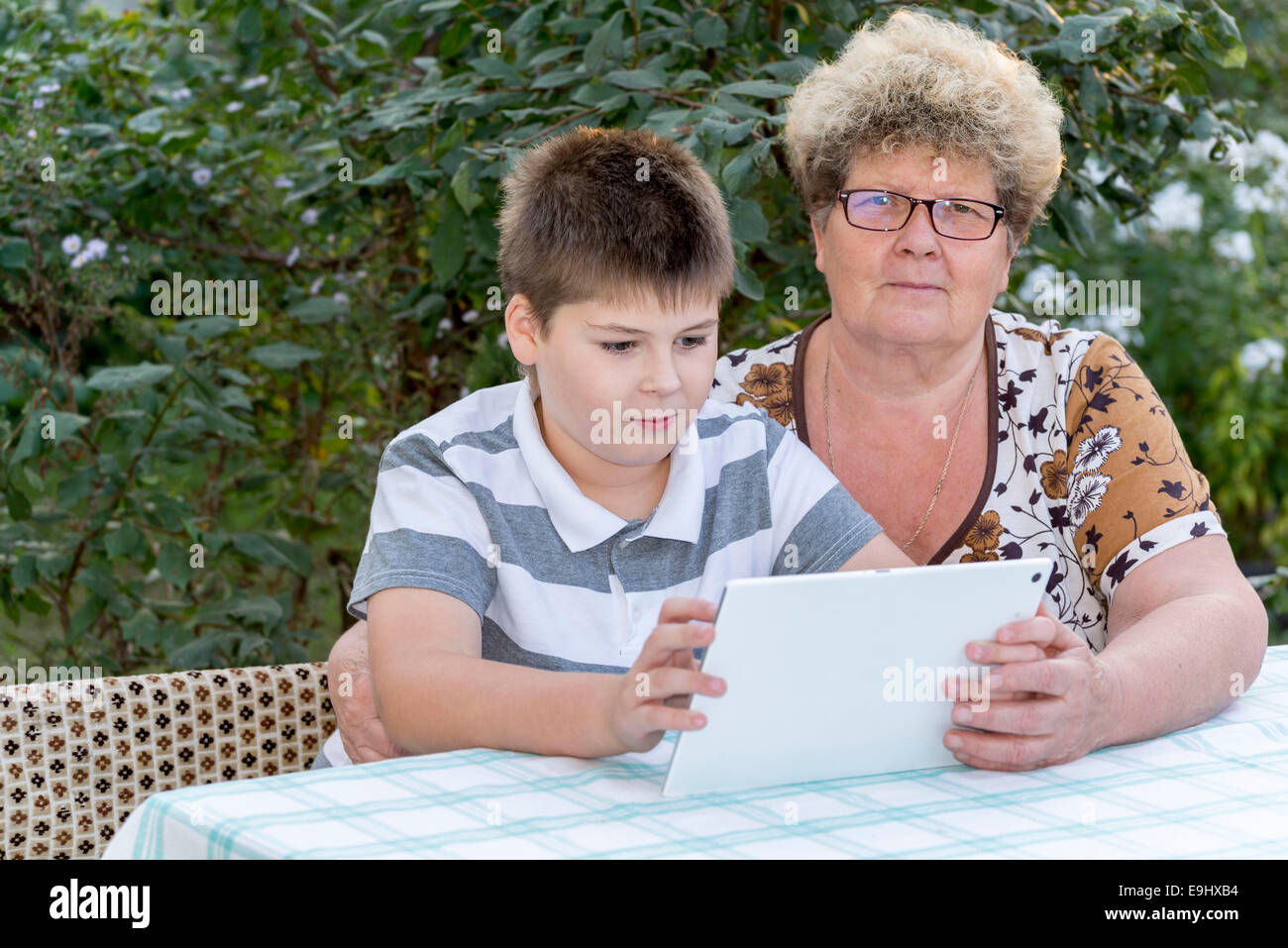 La nonna con nipote guardando la pastiglia in natura Foto Stock