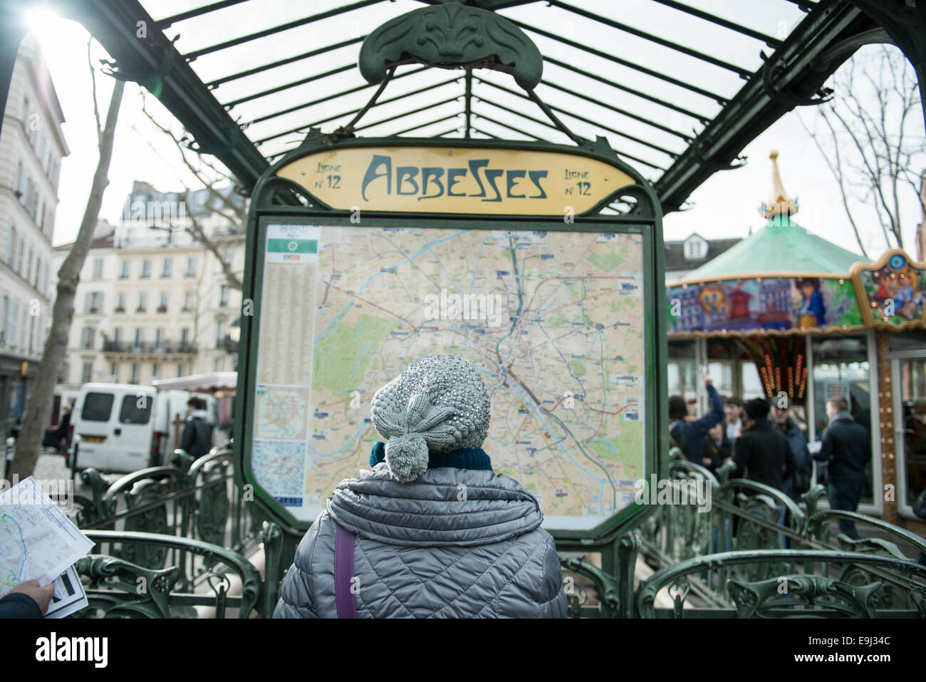 Una donna in un cappello legge il treno al di fuori della mappa a Parigi la stazione della metropolitana Foto Stock