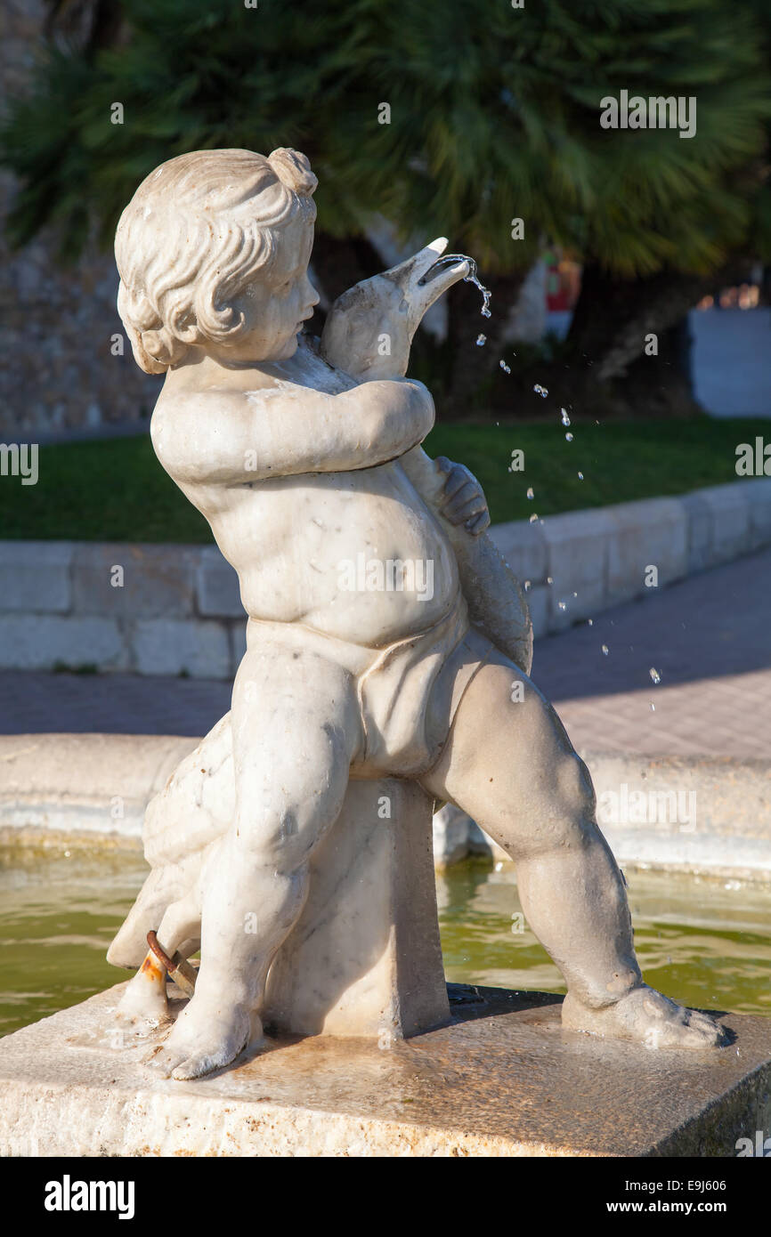 Statua di Little Boy con oca, street fontana in pietra bianca in Tarragona Catalogna Foto Stock